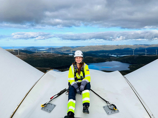 Margarita Aleksieva sitzt auf einer Windturbine.